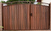 Arched, decorative, secure and useful RV gate.  The rust colored polyurethane paint and the redwood composite privacy slats comb