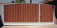 simple arched RV gate with redwood composite slats and white paint 
